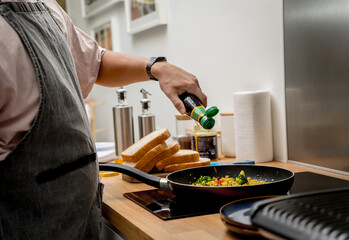 Chef at the kitchen preparing tofu scramble with vegetables
