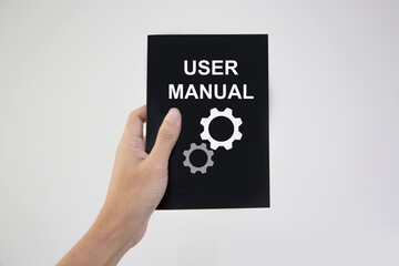 Hand holding user manual guide book