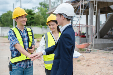 construction worker and contractor. Client shaking hands with team builder in renovation site in the morning.