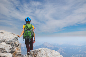 climber goes along the rocky ridge. girl climbing in the mountains. the concept of adventure and...
