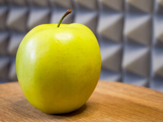 Apple on wooden texture, reflects organic quality, useful for eco-friendly product branding.