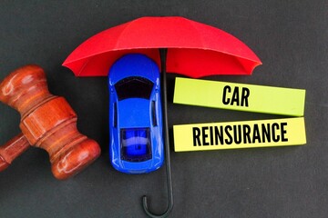 umbrella, judge's gavel, car and colored paper with the word car reinsurance. car insurance renewal