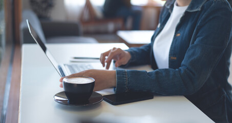 Business woman working on laptop computer at coffee shop. Female freelancer connecting the internet, online working from cafe, remote work, telecommuting, freelance lifestyle