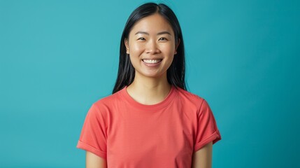 Create an image of a smiling Asian person. They are wearing a solid color t-shirt and standing in front of a solid color background. The person has light to medium skin and straight black hair.