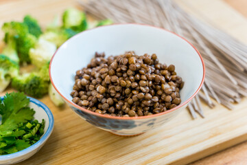 Cutting board with raw japanese buckwheat pasta and lentils