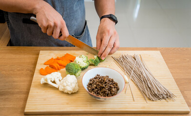 Chef at the kitchen preparing japanese buckwheat pasta with lentils