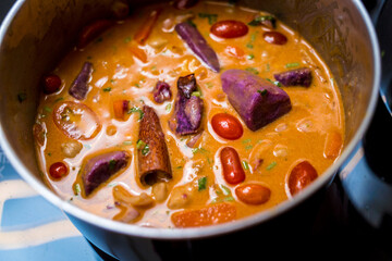 Chef at the kitchen preparing massaman curry with sweet potato and many spices