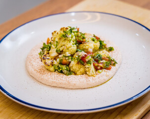 Tasty bean porridge with cauliflower and vegetables on white plate