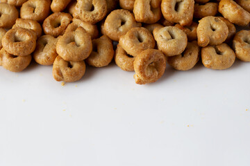 salty tarallini cookies scattered on a white background, copy space