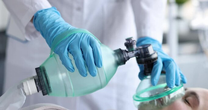 Doctor providing emergency care to patient using ambu bag closeup 4k movie slow motion. Cardiopulmonary resuscitation concept