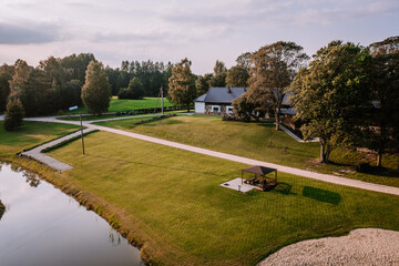 Blome, Latvia - September 11, 2023 - Aerial view of a rural property with a house, large lawn,...