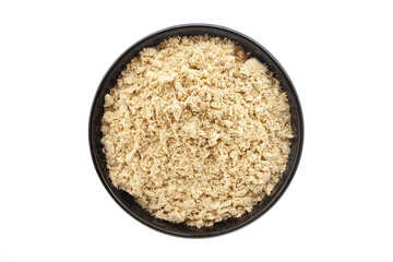Organic Chikpea Flour (Cicer arietinum) or Besan, in a black ceramic bowl. Isolated on a white background. Top View