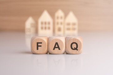 Cubes with message FAQ surrounded by wood home. Quesiton and answer about housing problems