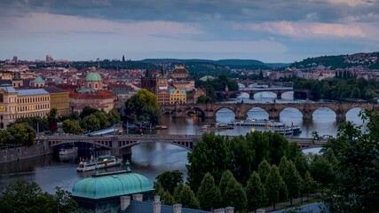 Panned summer sunset to night time lapse of the cityscape of Prague, Czech Republic, with the various bridges over Vltava River and the old town