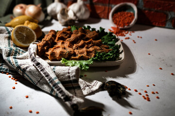 spirit of turkish traditional cuisine red lentil mercimek kofte served with lemon and green lettuce salad on white background