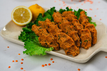 mercimek kofte, turkish lentil meatballs, vegan mediterranean food served with lemons and green salad