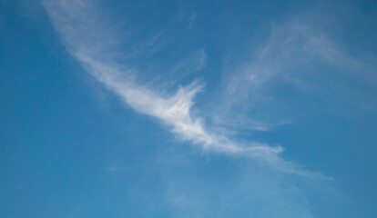 A small cloud high in the sky. Blue sky and clouds