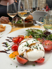 burrata cheese salad and wine glasses on table