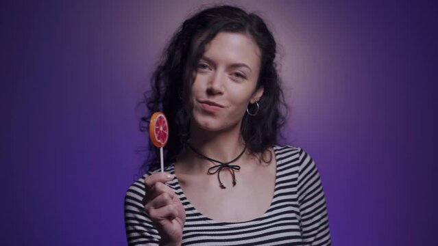 studio shot of dark hair woman with delicious candy