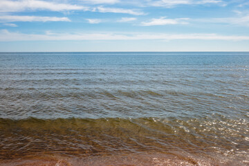 The clear water of Lake Michigan washed asrhore under the blue early June sky at Harrington Beach State Park, Belgium, Wisconsin