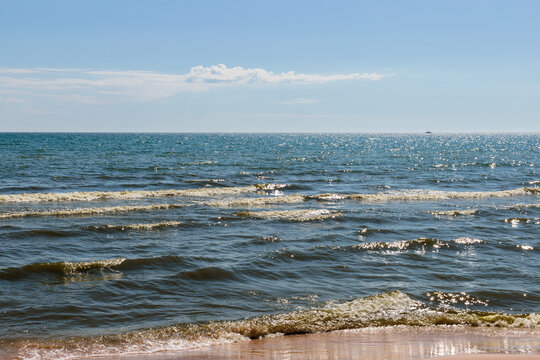 Looking out over Lake Michigan,  with the cassual incoming waves in early June, on a peaceful blue sky morning at Harrington Beach State Park, Belgium, Wisconsin