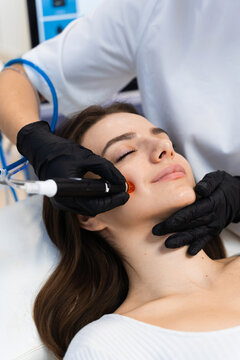 Cleansing skin with hydrafacial hardware at cosmetologist. Hydrafacial facial cleansing skincare procedure to moisturizing facial skin.