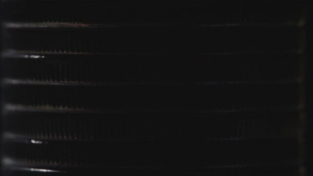 Stack of silver coins in close-up, texture of old coins, light movements, dark background 