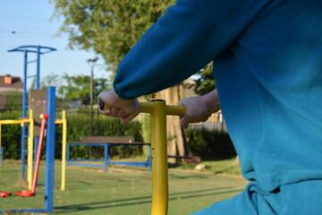 A dedicated young athlete puts in the hard work, vigorously training on gym equipment outdoors to...