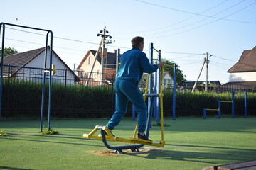 A dedicated young athlete puts in the hard work, vigorously training on gym equipment outdoors to...