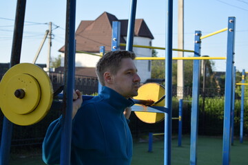 A dedicated young athlete puts in the hard work, vigorously training on gym equipment outdoors to...