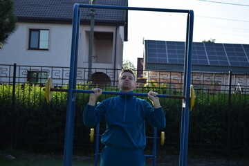 A dedicated young athlete puts in the hard work, vigorously training on gym equipment outdoors to...