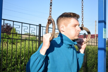 A dedicated young athlete puts in the hard work, vigorously training on gym equipment outdoors to...