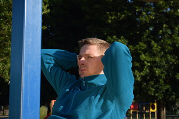 A dedicated young athlete puts in the hard work, vigorously training on gym equipment outdoors to...