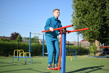 A dedicated young athlete puts in the hard work, vigorously training on gym equipment outdoors to...