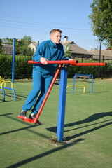 A dedicated young athlete puts in the hard work, vigorously training on gym equipment outdoors to...