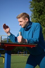 A dedicated young athlete puts in the hard work, vigorously training on gym equipment outdoors to...