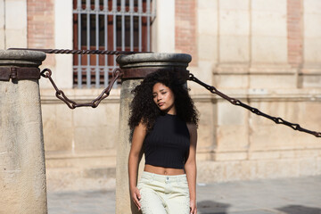 beautiful young latin woman with black and dark eyes and long curly hair with a sad expression...