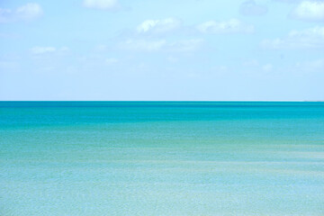 Blue sky, clouds and background with sea in nature for calm water, peace and outdoor environment. Trip, coast and wallpaper of ocean in morning for climate, ecology and travel destination in Cancun