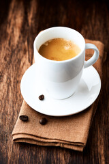 Cup of coffee on wooden background. Close up.
