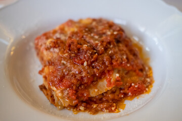 Lasagna served on plate. It is an Italian dish made of stacked layers of wide flat sheet pasta alternating with fillings