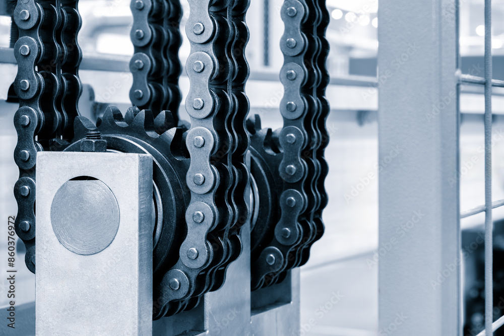 Poster a chain is shown in a factory setting. the chain is black and silver. the chain is attached to a met