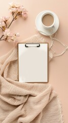 Obraz premium Flat lay, top view home office desk table with blank clipboard, blanket and cup of coffee on beige background. Modern feminine workspace concept 