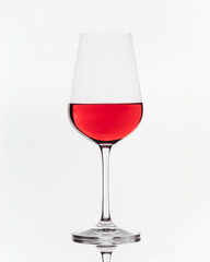 An elegant glass of red wine perfectly balanced against a white background.