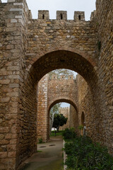 Fototapeta premium stone gate through Lagos city stone walls Porta de São Gonçalo original historic landmark site protecting barricade that surrounds Algarve town in Portugal with trees next to entrance