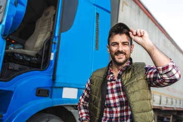 Happy confident male driver standing in front on his truck