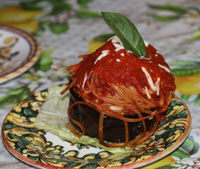 Melanzana ripiena di spaghetti con salsa di pomodoro e ricotta salata