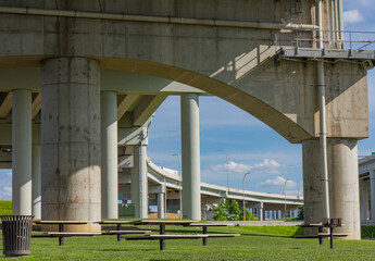 The supports and open space underneath Interstate 65 in Waterfront Park in Louisville, Kentucky with picnic tables.