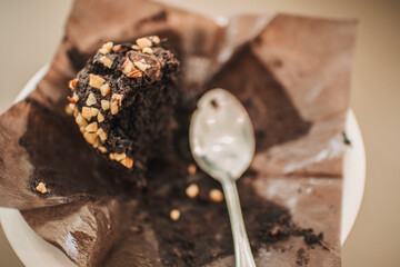 Close up and top view of eaten chocolate muffin cake with dirty spoon.