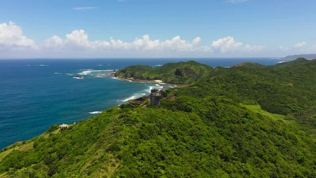 Aerial drone of Lighthouse on the background of the blue ocean. Cape Engano. Palaui Island. Santa Ana Philippines.