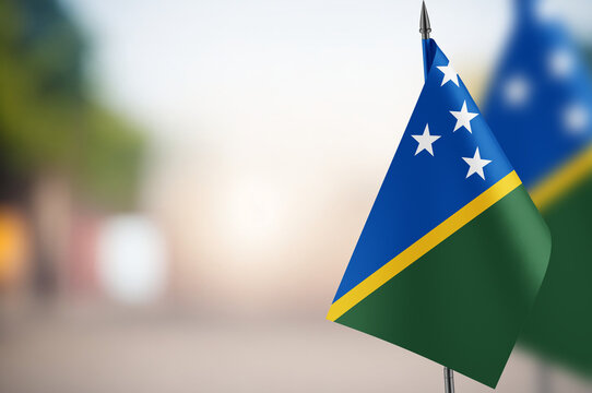 Small flags of Solomon Islands on a blurred background